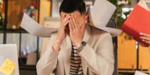 사무실에서 가슴을 붙잡고 심장두근거림을 느끼는 직장인의 모습