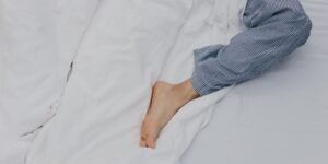 하지불안증후군 증상으로 잠들지 못하는 직장인의 다리 모습